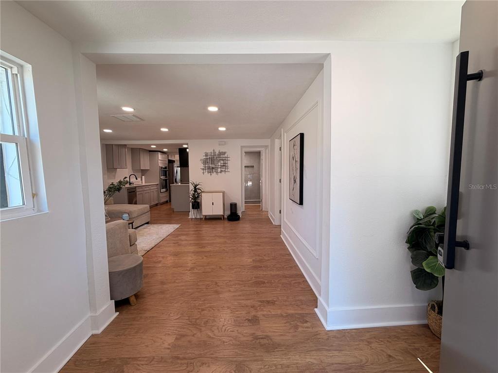 An entryway leads into an open-concept living room and kitchen with light wood-look flooring — 211 BAYSHORE DRIVE, ORLANDO, FL