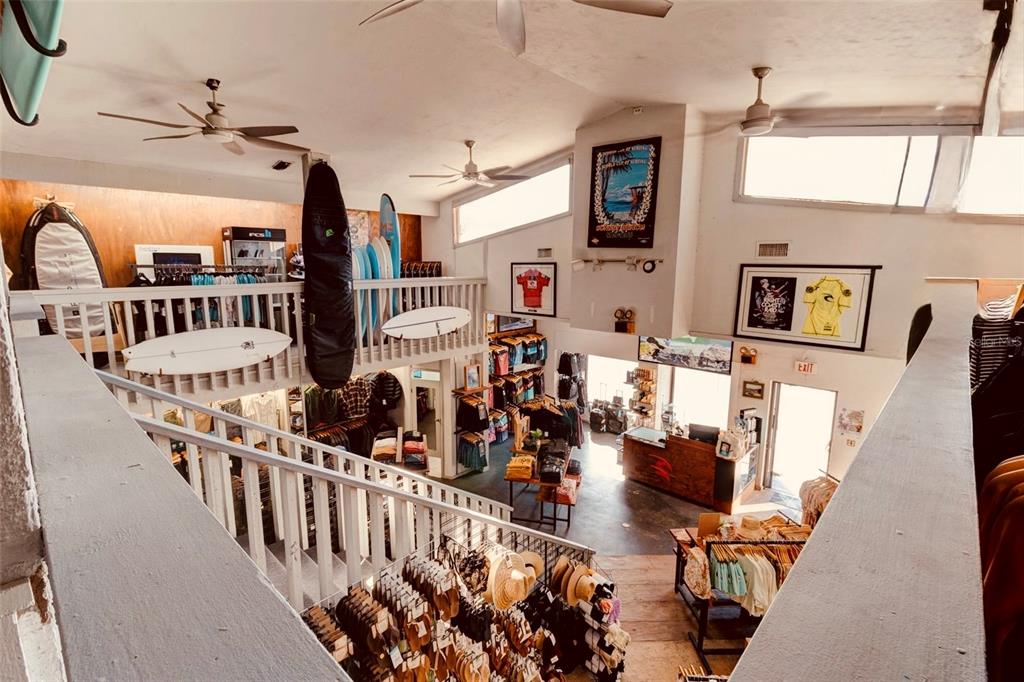 An elevated view of a surf shop interior featuring a mezzanine level and retail displays — 510 FLAGLER AVENUE, NEW SMYRNA BEACH, FL
