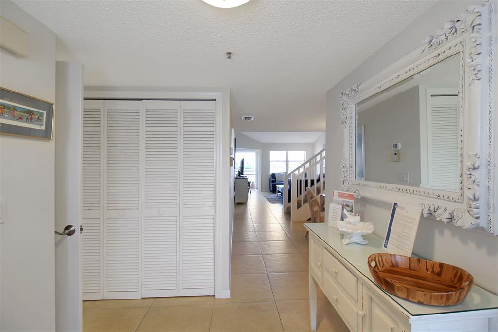 A tiled entryway leads to a living area with stairs and a white louvered closet — 1391 SIESTA BAYSIDE DRIVE UNIT 1391-B, SARASOTA, FL