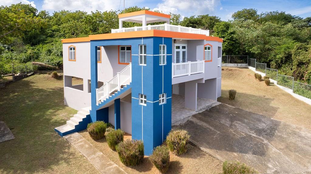 An elevated two-story house with blue and grey exterior walls, a balcony, and stairs — 78 HIDDEN PARADISE, VIEQUES, PR
