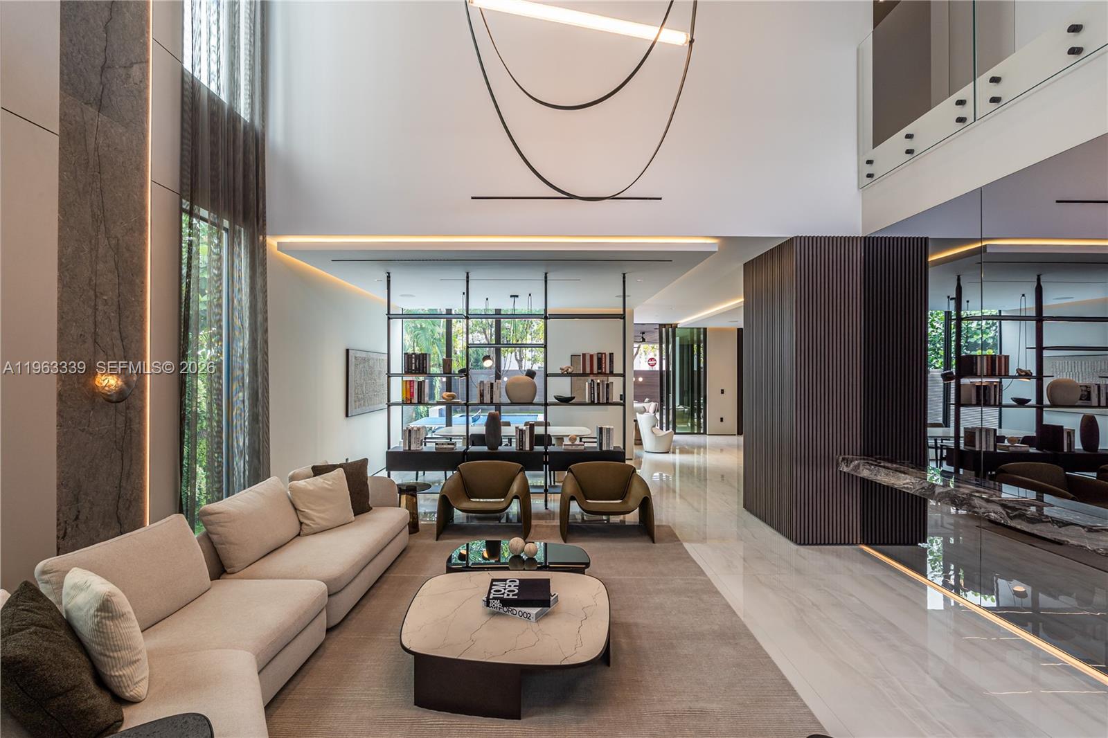A modern living room features high ceilings, a marble floor, and a central shelving unit — 10540 NW 67th Ter, Doral FL 33178, DORAL, FL