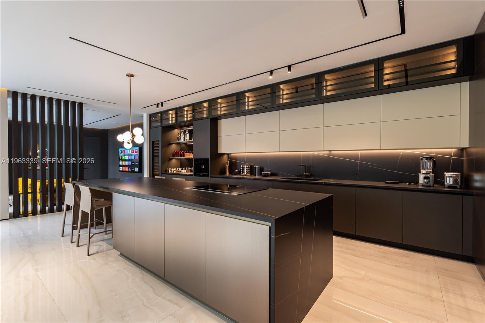 A modern kitchen features a large dark island, matte cabinetry, and integrated under-cabinet lighting — 10540 NW 67th Ter, Doral FL 33178, DORAL, FL