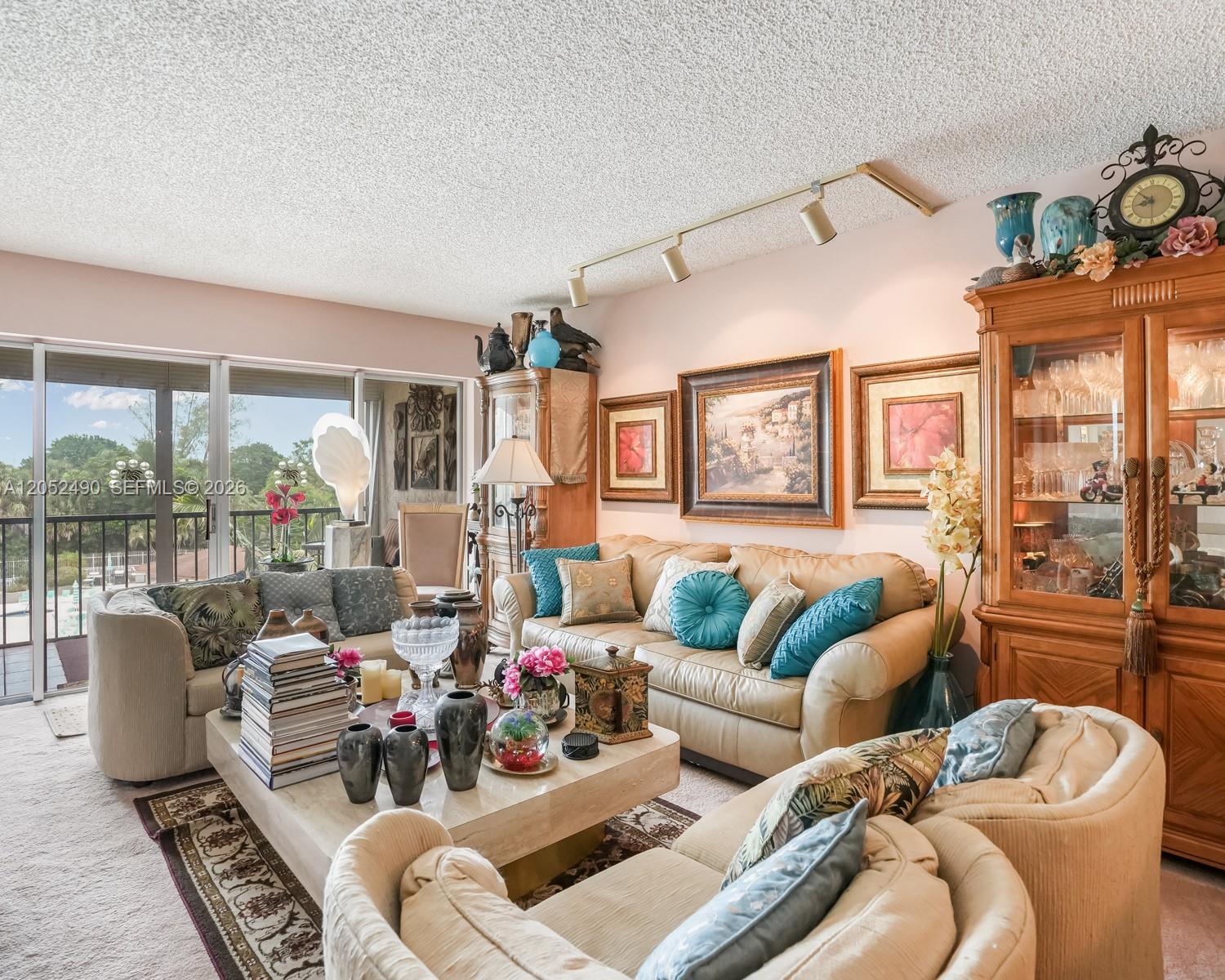 A living room features beige sofas, a stone coffee table, and a large wooden cabinet — 3930 Inverrary Blvd # D, Lauderhill FL 33319, LAUDERHILL, FL