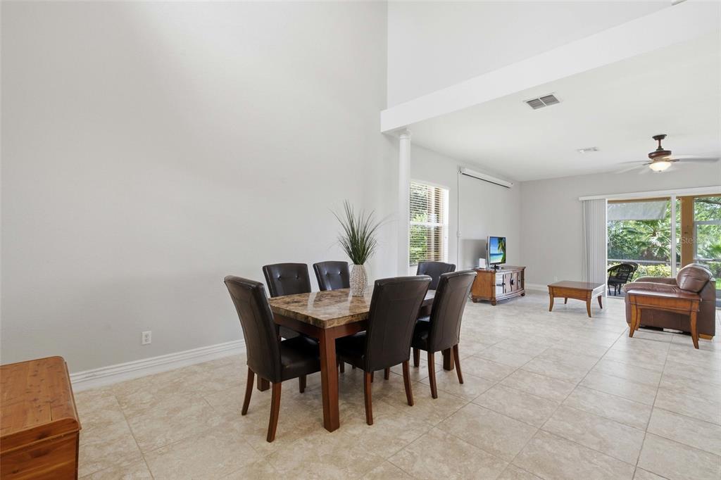 A dining area with a marble-topped table sits in an open-concept room with tile floors — 2513 KEYSTONE LAKE DRIVE, CAPE CORAL, FL