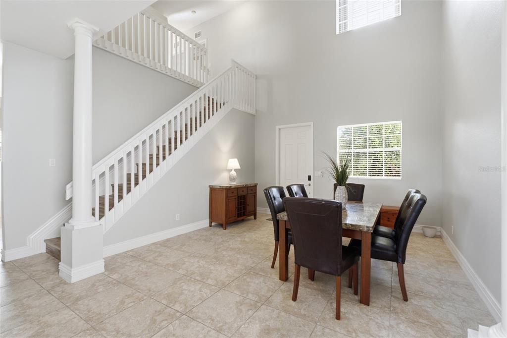 A dining area with tile floors, a staircase, and a table with four chairs — 2513 KEYSTONE LAKE DRIVE, CAPE CORAL, FL