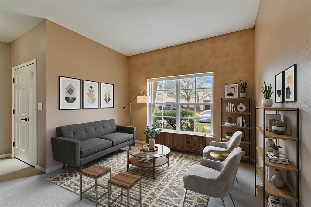A living room with a gray sofa, two armchairs, a coffee table, and a bookshelf — 10328 CELTIC ASH DRIVE, RUSKIN, FL
