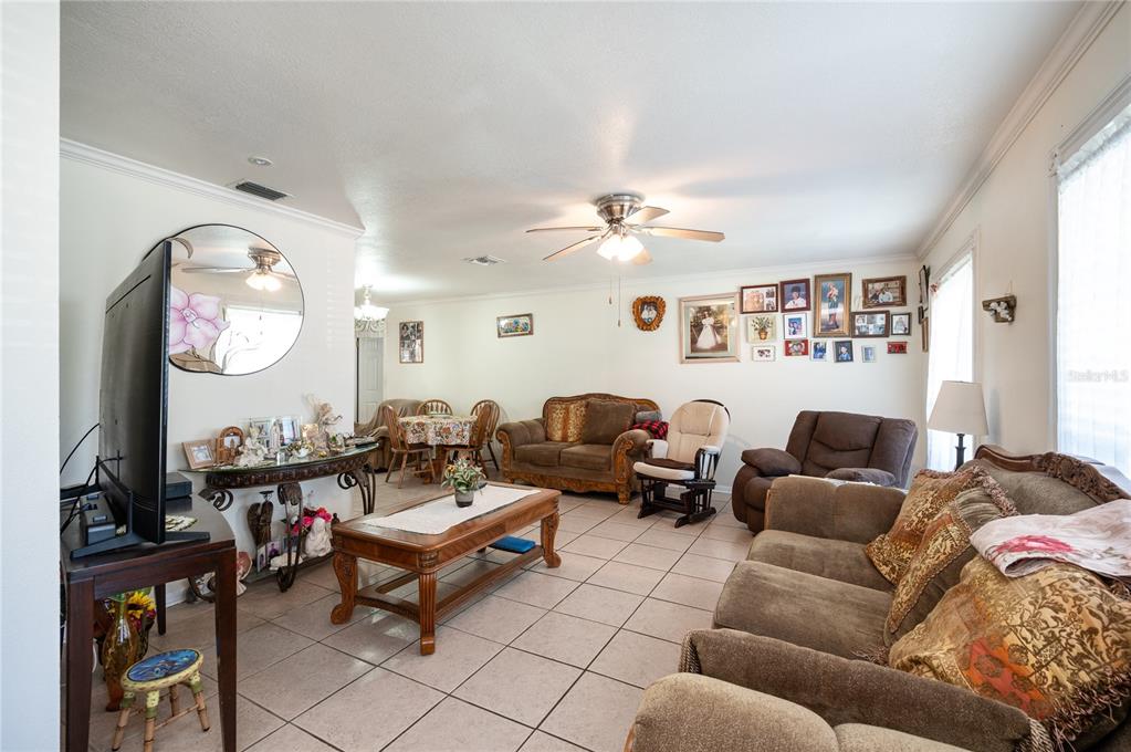 A living room with tile flooring, a ceiling fan, and a gallery wall of photos — 520 SAN SEBASTIAN PRADO, ALTAMONTE SPRINGS, FL