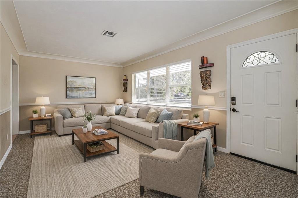A living room features a sectional sofa, an armchair, a coffee table, and a door — 2049 50th Avenue, Vero Beach FL 32966, VERO BEACH, FL