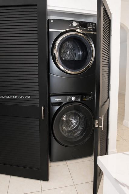A stacked black washer and dryer set is housed inside a closet with louvered doors — 5373 W 24th Ct # 5373, Hialeah FL 33016, HIALEAH, FL
