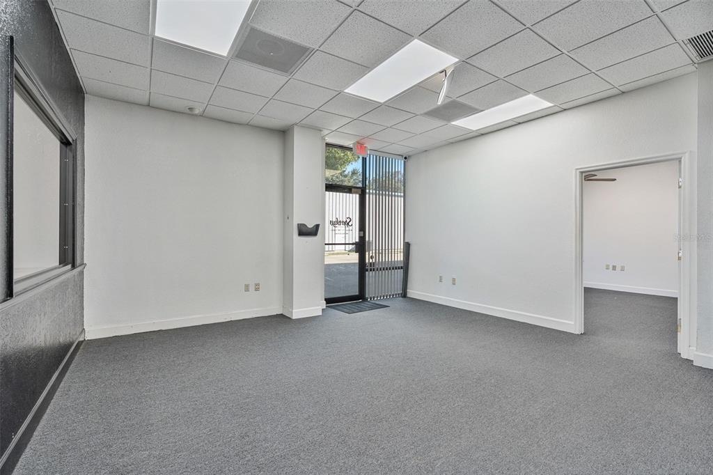 An empty office space features gray carpeting, white walls, a drop ceiling, and a glass door — 210 E PALMETTO AVENUE, LONGWOOD, FL