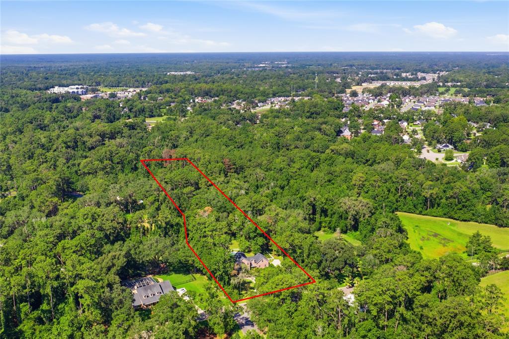 A two-story brick house with a backyard swimming pool and a paved patio area — 11121 NW 15TH PLACE, GAINESVILLE, FL