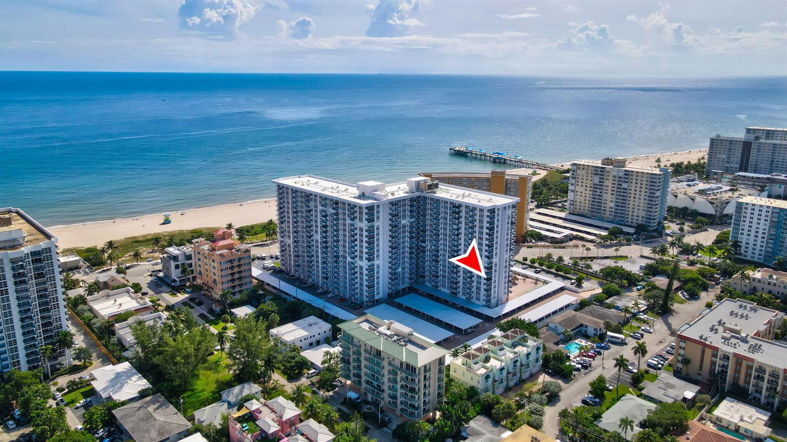 An aerial view shows a large beachfront apartment complex with a pool and parking area — 405 N Ocean Boulevard # 329, Pompano Beach FL 33062, POMPANO BEACH, FL