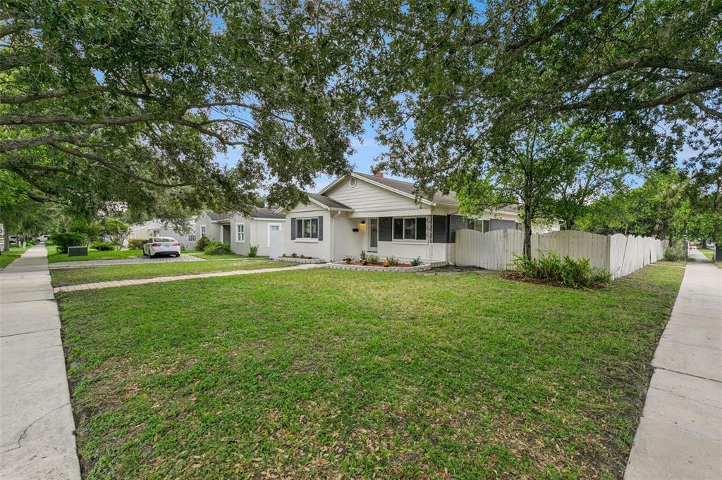 A single-story house with white siding and a large front lawn under mature trees — 1652 BERKSHIRE AVENUE, WINTER PARK, FL