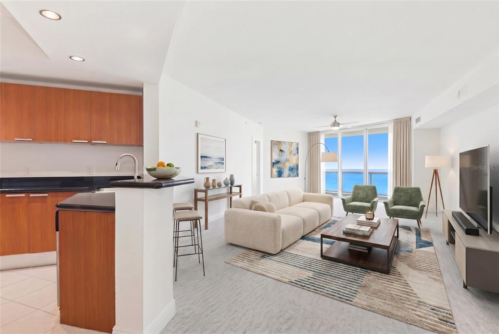 An open-concept living room and kitchen featuring wood cabinets, a beige sofa, and ocean views — 241 RIVERSIDE DRIVE UNIT 1604, HOLLY HILL, FL