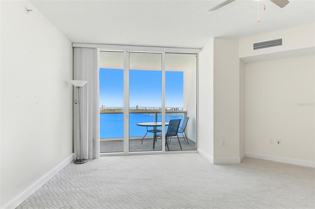 A carpeted living room features a sliding glass door opening to a balcony with water views — 241 RIVERSIDE DRIVE UNIT 1604, HOLLY HILL, FL
