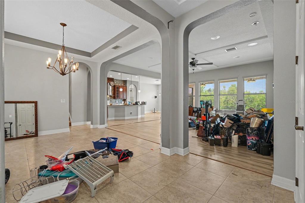 A tiled entryway leads to an open living area and a kitchen with wood cabinets — 31957 MARDELLE PLACE, WESLEY CHAPEL, FL