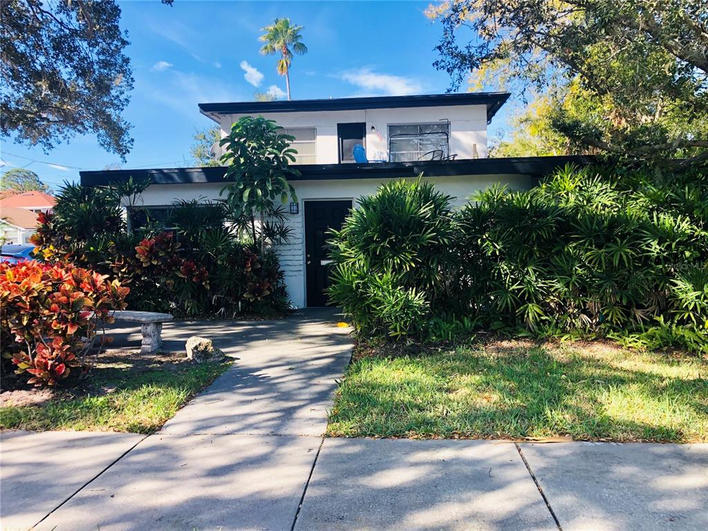A two-story white house with a flat roof is surrounded by lush tropical landscaping — 1762 N FORT HARRISON AVENUE, CLEARWATER, FL