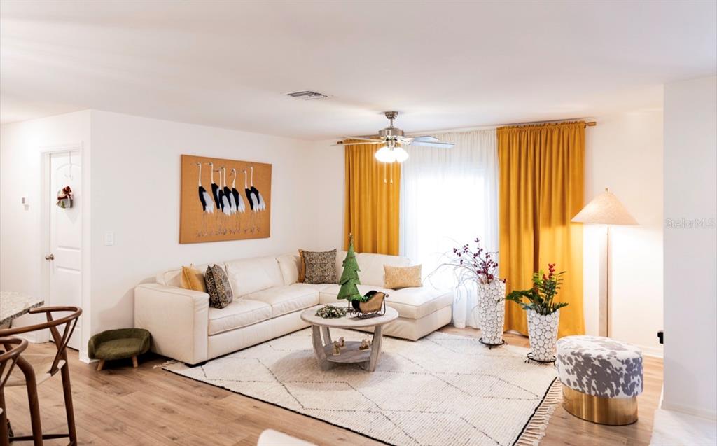 A living room features a white sectional sofa, yellow curtains, and a patterned area rug — 1660 LANSDALE AVENUE, NORTH PORT, FL