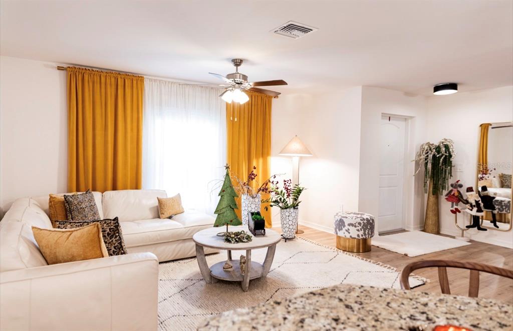 A living room features a white sectional sofa, yellow curtains, and a round coffee table — 1660 LANSDALE AVENUE, NORTH PORT, FL