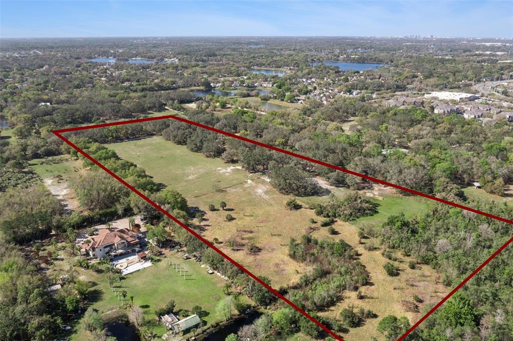 An aerial view shows a large, rectangular plot of land outlined in red near a house — LOT 3 OAK HOLLOW, OVIEDO, FL