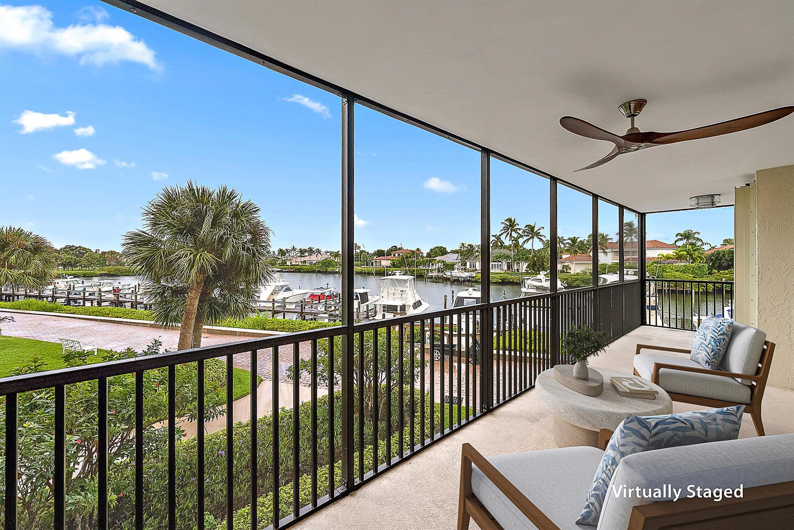 A screened balcony features outdoor seating, a ceiling fan, and a view of a marina — 16910 Bay Street # E204, Jupiter FL 33477, JUPITER, FL