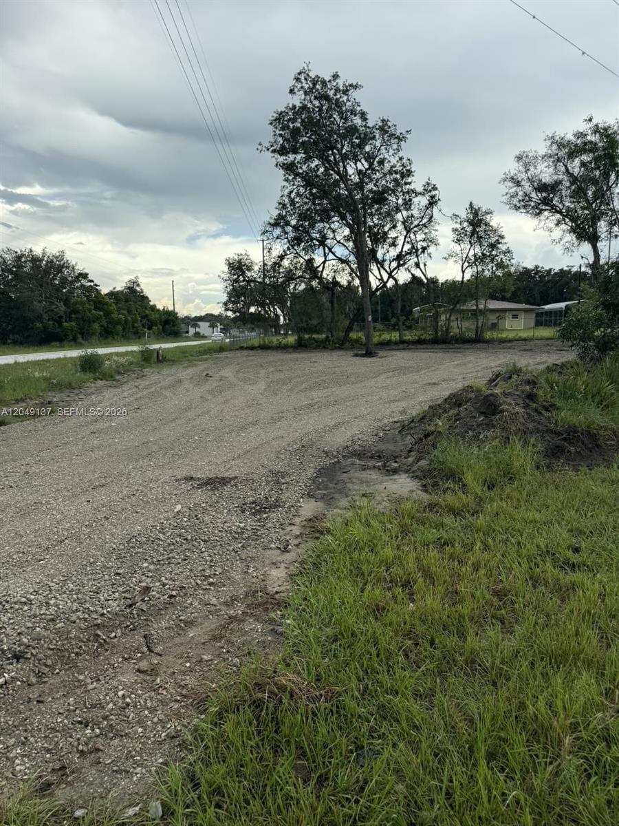 A gravel driveway leads toward trees and a house in the distance — 4732 Kenilworth Blvd, Sebring FL 33872, SEBRING, FL