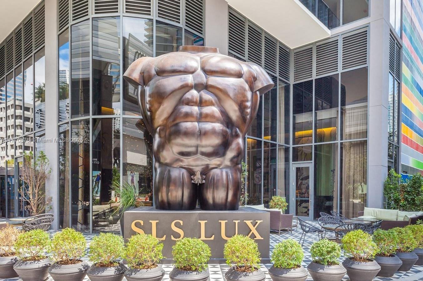 A large bronze torso sculpture stands on a pedestal in front of the SLS LUX building — 801 S Miami Ave # 4308, Miami FL 33130, MIAMI, FL