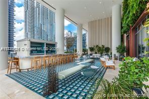 An outdoor lounge area features a bar, seating, and a green wall under a canopy — 801 S Miami Ave # 4308, Miami FL 33130, MIAMI, FL