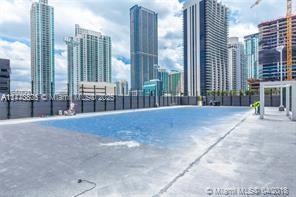 A rooftop swimming pool overlooks a city skyline with several high-rise buildings — 801 S Miami Ave # 4308, Miami FL 33130, MIAMI, FL