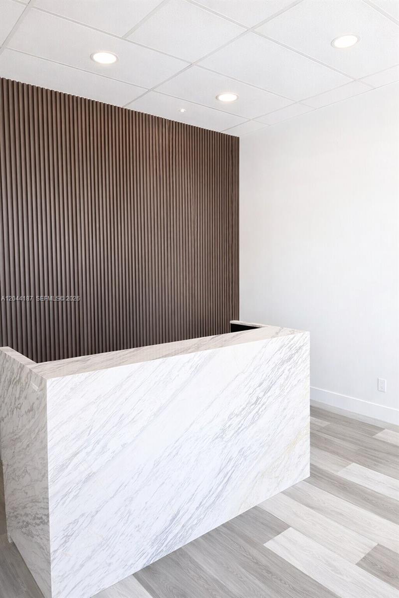 A reception desk with a marble finish stands before a dark wood slat accent wall — 3241 NW 7th St # 3251, Miami FL 33125, MIAMI, FL
