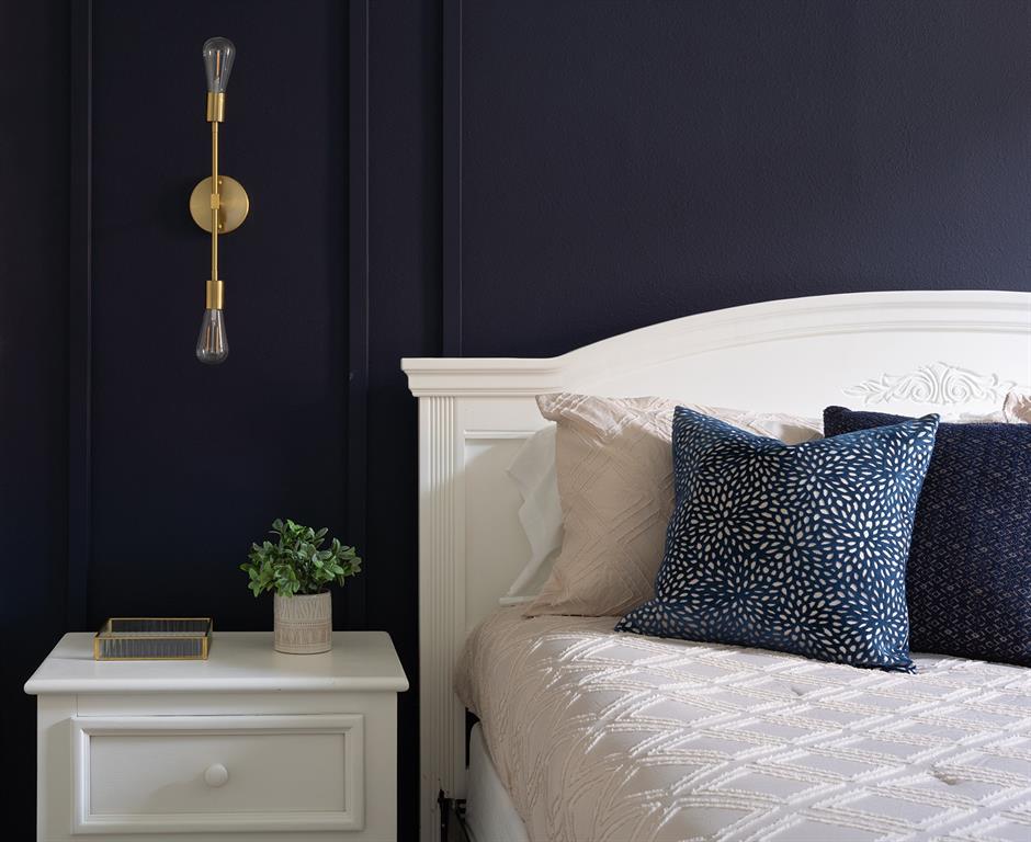 A bedroom features a white nightstand, a white headboard, and a gold wall sconce — 2739 SUN KEY PLACE, KISSIMMEE, FL