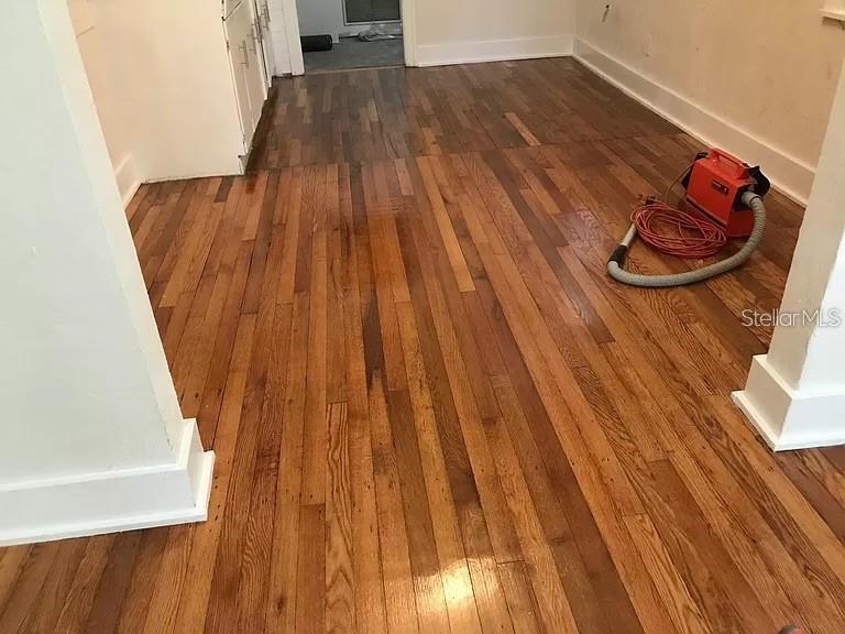 A room with hardwood floors, white trim, and a portable vacuum cleaner on the floor — 545 15TH AVENUE S, ST PETERSBURG, FL