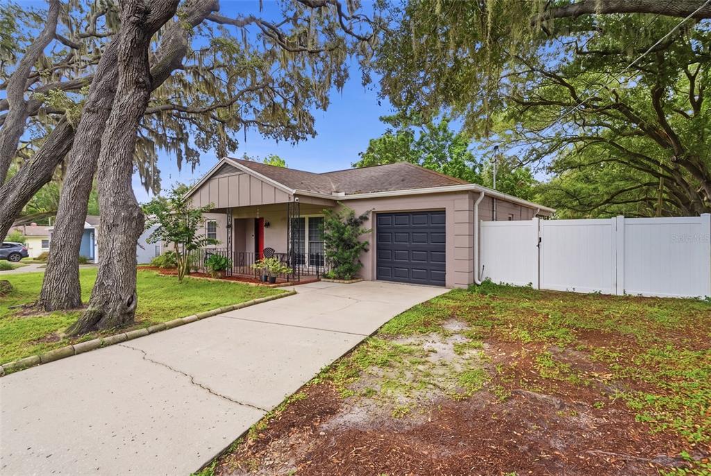 A single-story house with a concrete driveway, a garage, and a white privacy fence — 1901 E DIANA STREET, TAMPA, FL