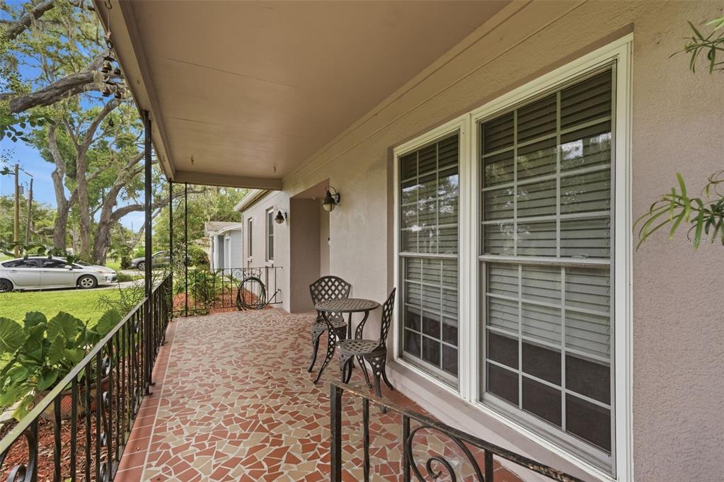 A covered porch features a mosaic tile floor, wrought iron railings, and a small bistro set — 1901 E DIANA STREET, TAMPA, FL
