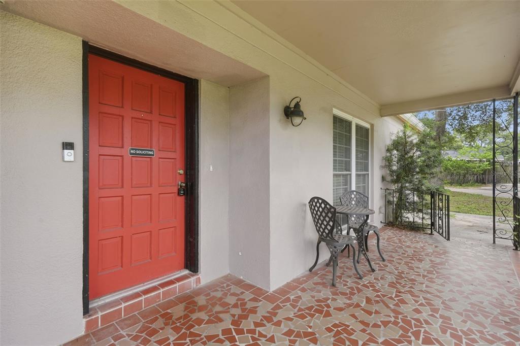 A red front door opens onto a covered porch with a mosaic tile floor — 1901 E DIANA STREET, TAMPA, FL