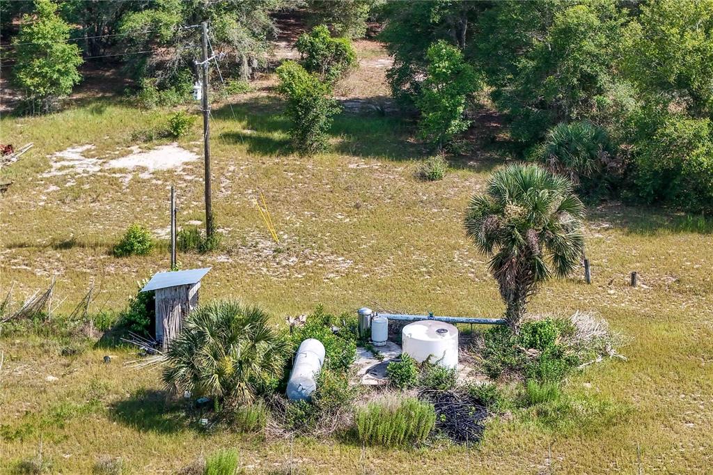 An aerial view shows a utility area with a shed, water tanks, and a palm tree — 5501 CEMETERY & SADLER ROADS, MOUNT DORA, FL