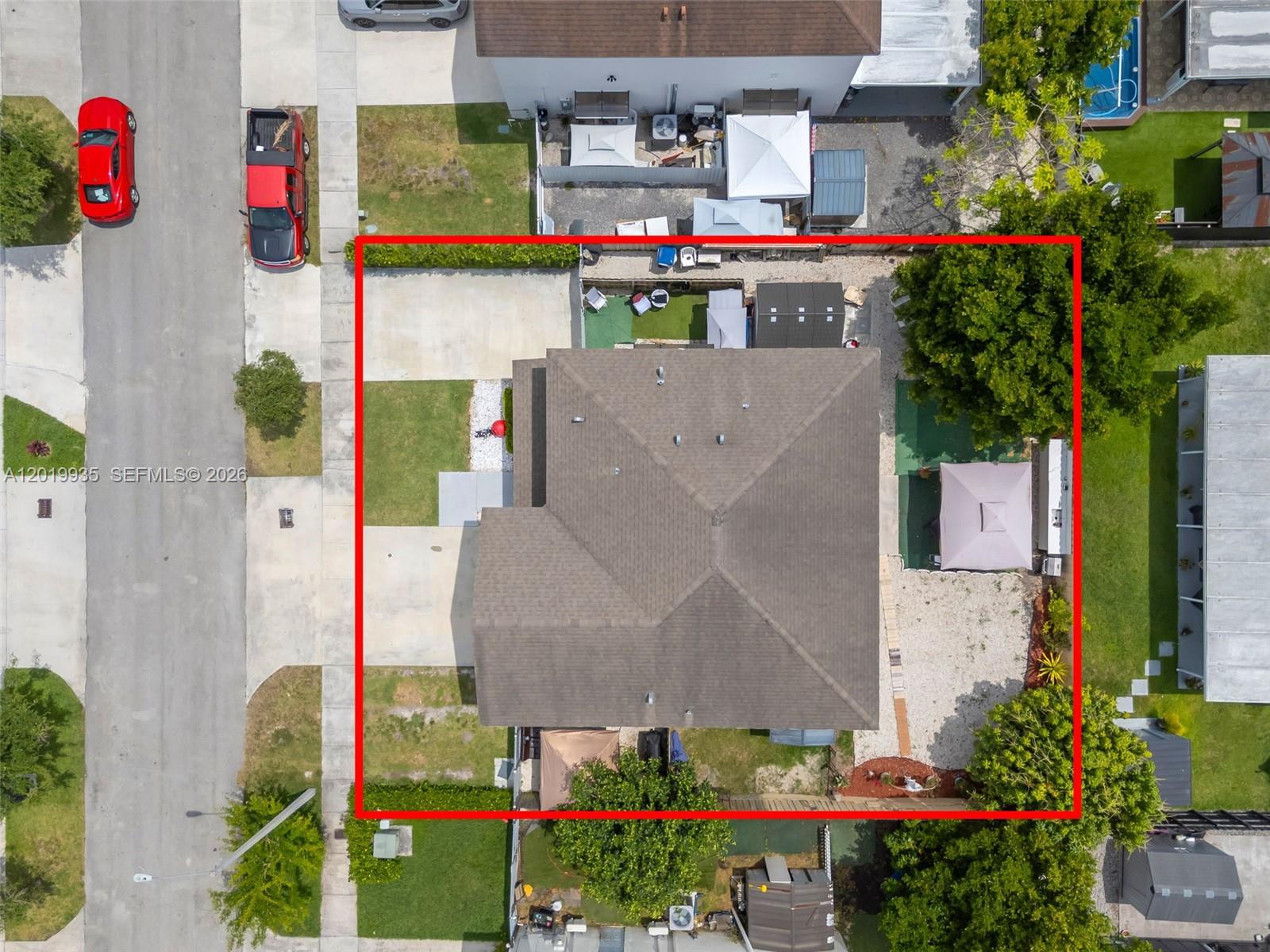 An aerial view shows a residential house with a brown roof inside a red border — HOMESTEAD, FL