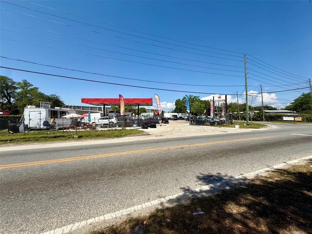 A roadside lot features a red-roofed fuel canopy, a food trailer, and parked vehicles — 2658 OVERLAND ROAD, APOPKA, FL