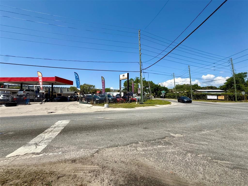 An outdoor view of a car dealership lot with a red canopy and parked vehicles — 2658 OVERLAND ROAD, APOPKA, FL