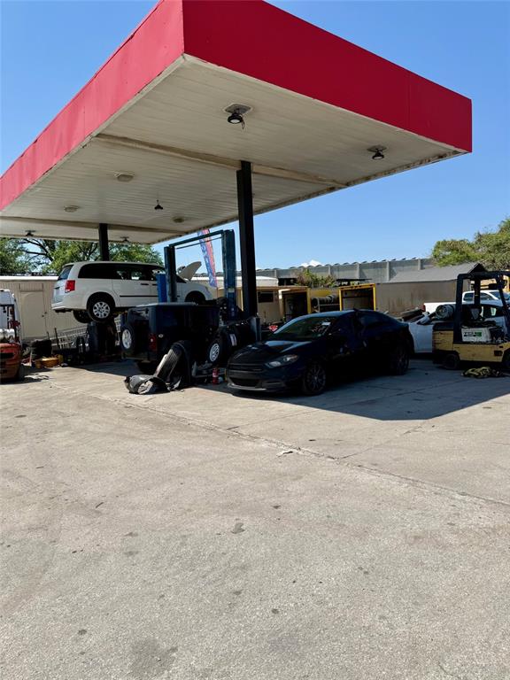 A red-roofed service station canopy covers a work area with cars and a forklift — 2658 OVERLAND ROAD, APOPKA, FL