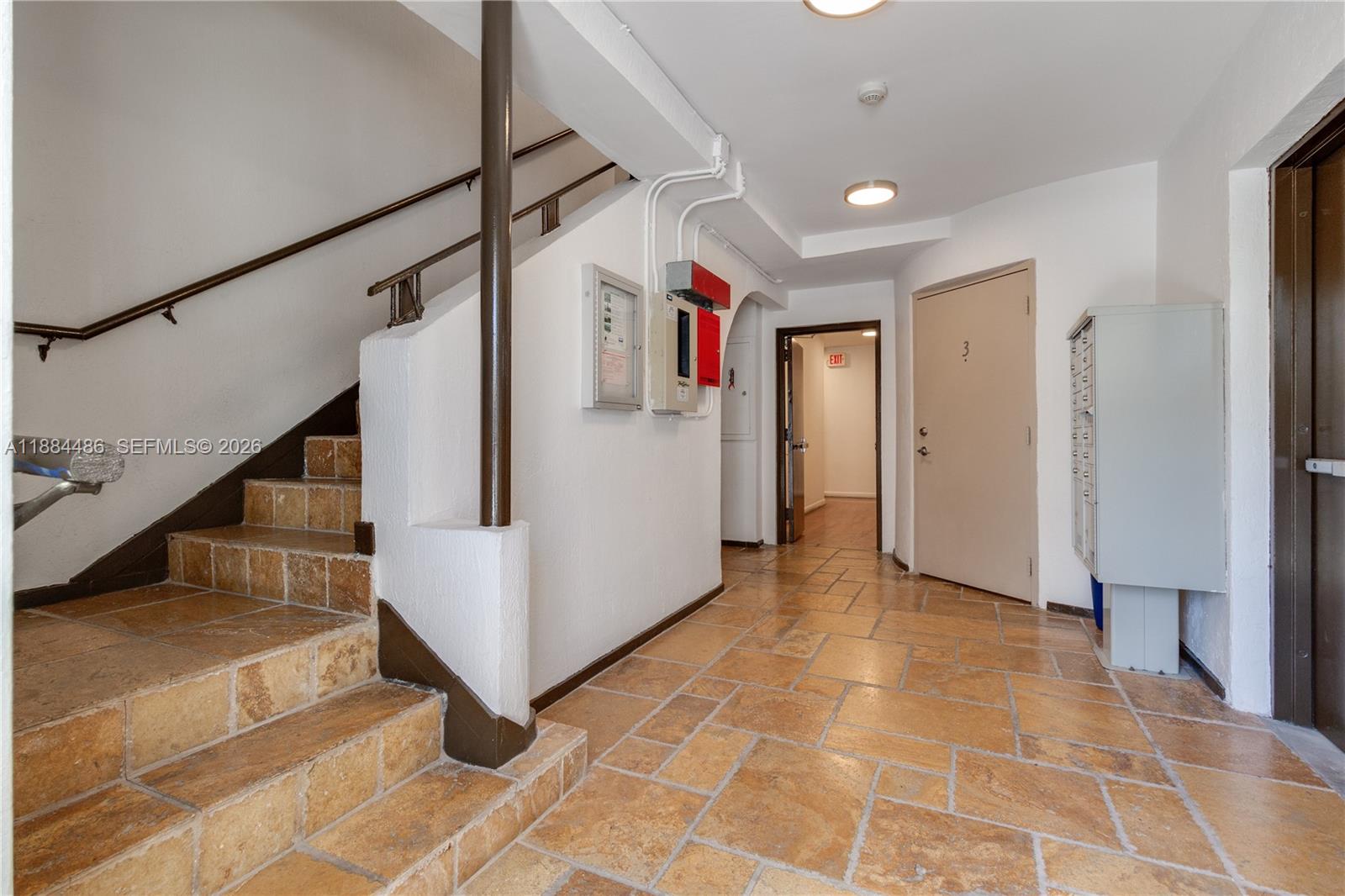 The exterior of a white multi-story apartment building features green landscaping and a sidewalk — 1241 14th St # 9, Miami Beach FL 33139, MIAMI BEACH, FL