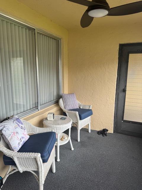 A covered patio features two white wicker chairs, a small round table, and a ceiling fan — 409 Pine Glen Lane # 1, FL 33463, FL