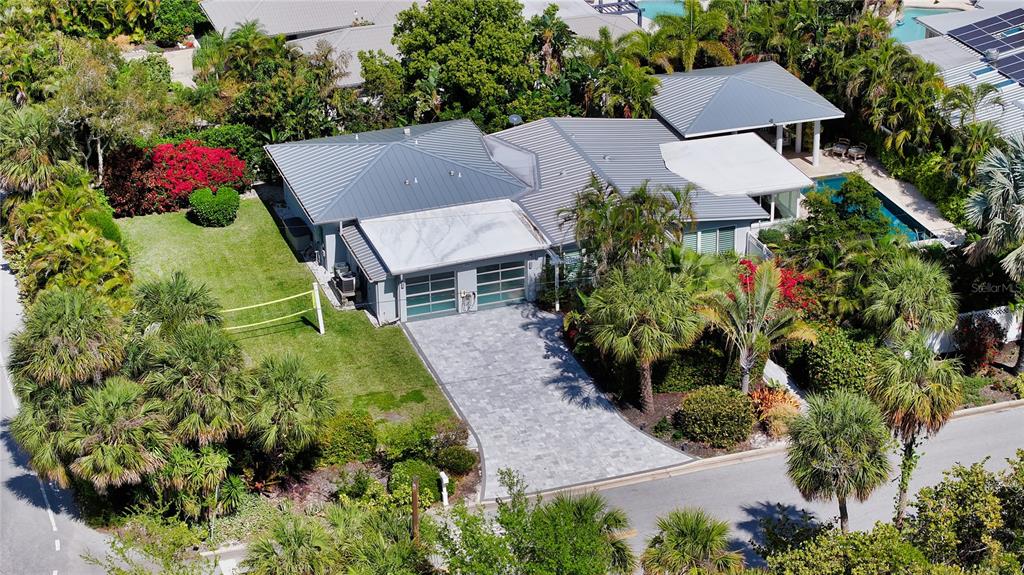 An aerial view of a house with a gray metal roof, paved driveway, and pool — 425 MCKINLEY DRIVE, SARASOTA, FL