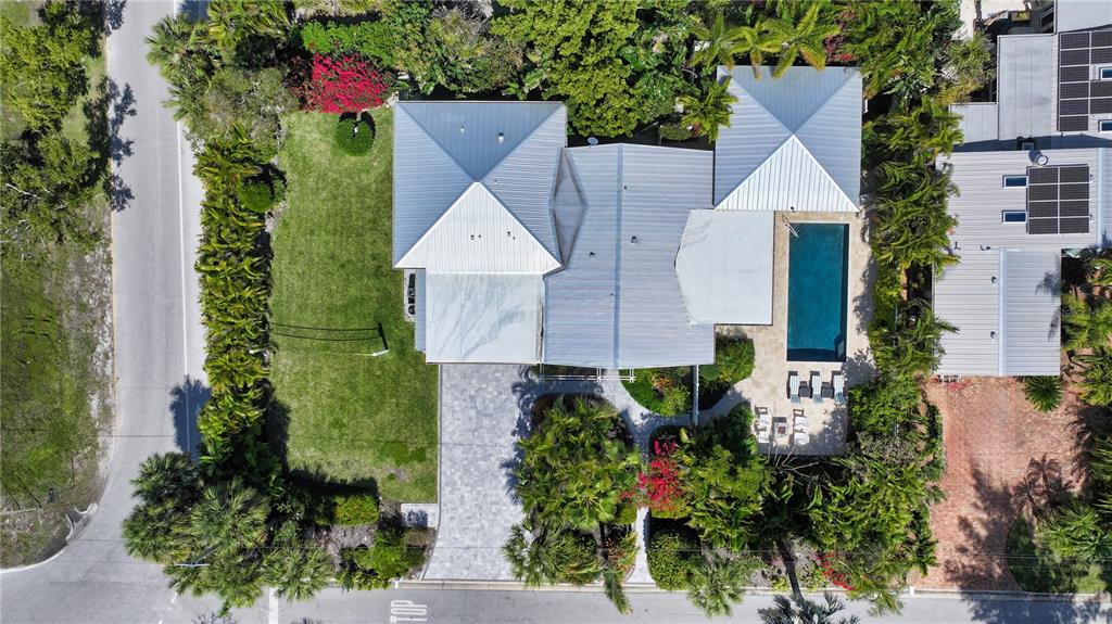 An aerial view shows a house with a metal roof, swimming pool, and landscaped yard — 425 MCKINLEY DRIVE, SARASOTA, FL