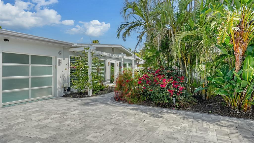 A paved driveway leads to a modern house exterior with a frosted glass garage door — 425 MCKINLEY DRIVE, SARASOTA, FL