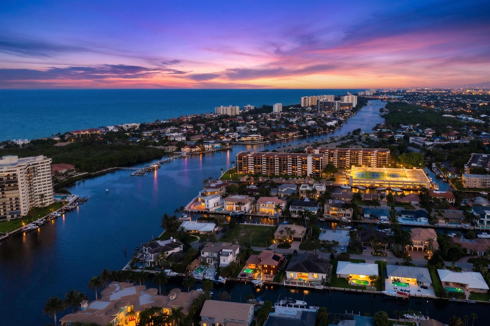 An aerial view of a coastal neighborhood with canals, residential homes, and apartment buildings at sunset — 876 Forsyth Street, Boca Raton FL 33487, BOCA RATON, FL