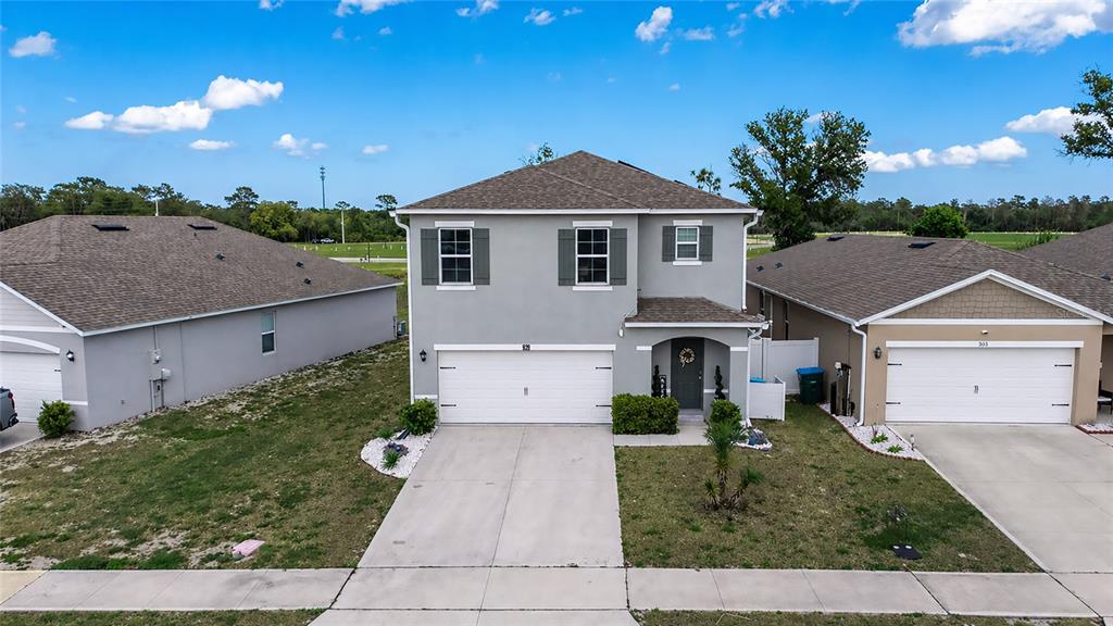 A two-story suburban house with a gray stucco exterior, a two-car garage, and a driveway — 928 AUGUST SKY DRIVE, DELTONA, FL