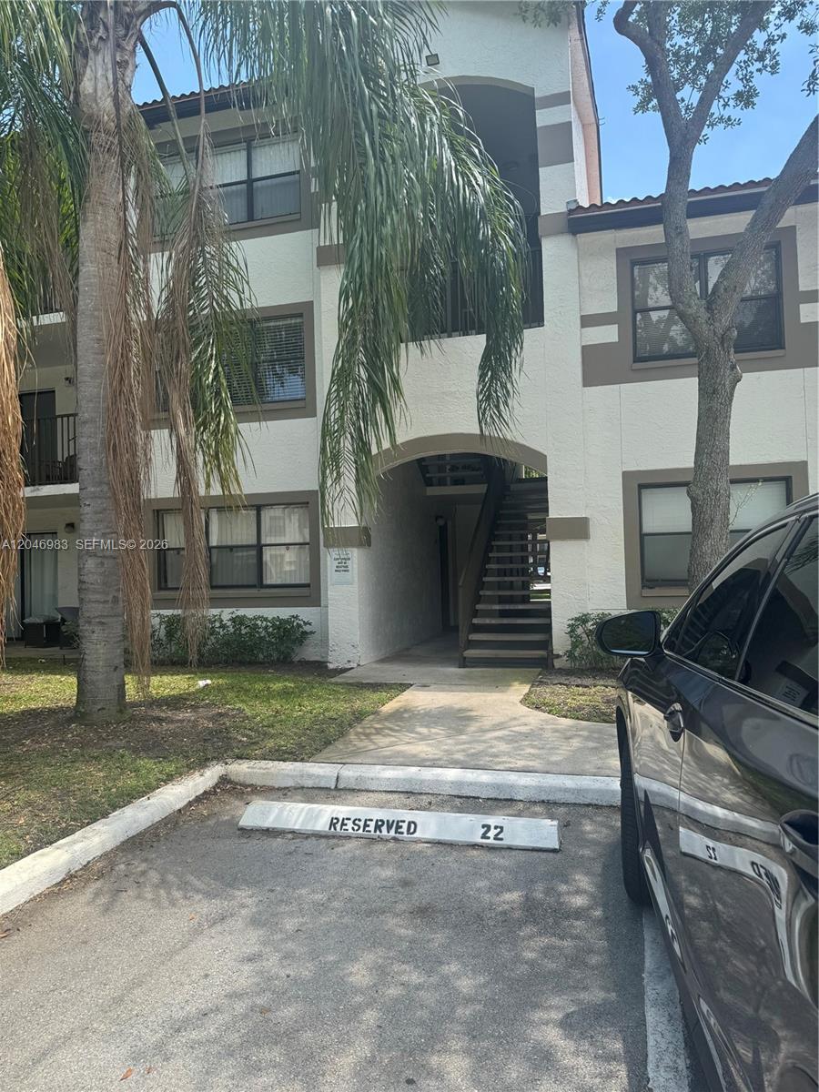 A three-story apartment building exterior features a reserved parking space in the foreground — 520 S Park Rd # 12, Hollywood FL 33021, HOLLYWOOD, FL