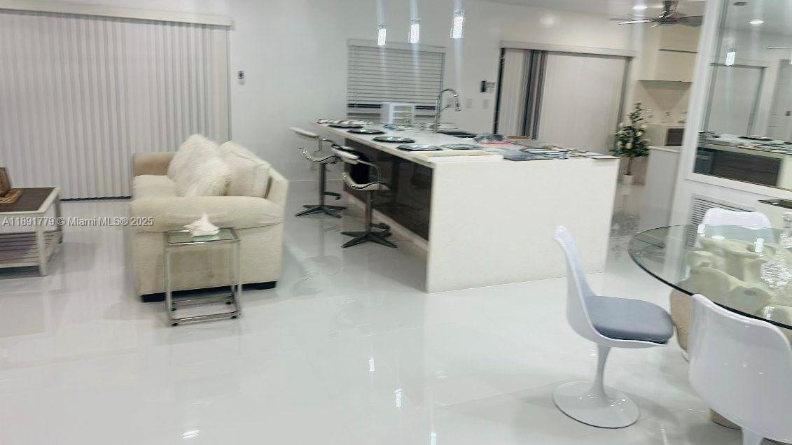A bright, open-concept kitchen and living area features white tile floors and modern furniture — 541 SE 17th Ave # 541, Deerfield Beach FL 33441, DEERFIELD BEACH, FL