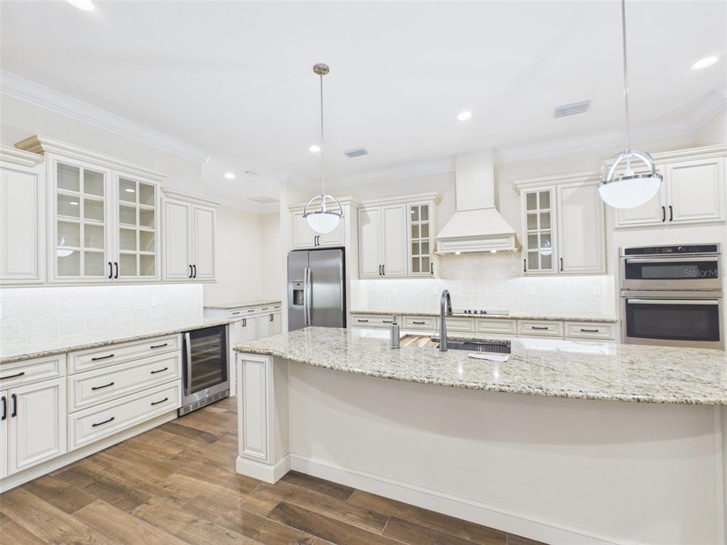 A kitchen with white cabinetry, granite countertops, a large island, and stainless steel appliances — 7695 SW 188 AVENUE, DUNNELLON, FL